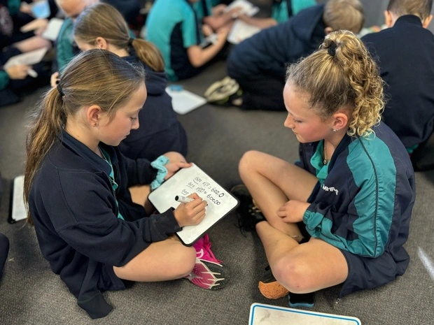 A teacher exemplifying one of the 10 essential classroom management skills as her class is focused and organised.